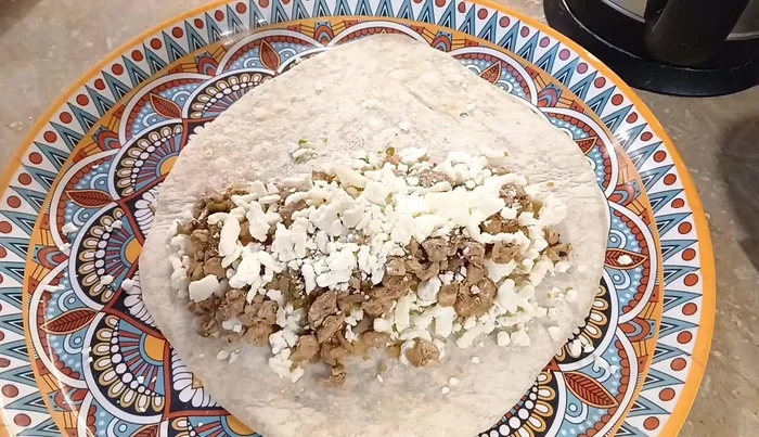 Assemble the quesadillas: Place a tortilla on a surface, add cheese, chicken filling (optional additions: mayo, ketchup, chilli sauce), and top with another tortilla.