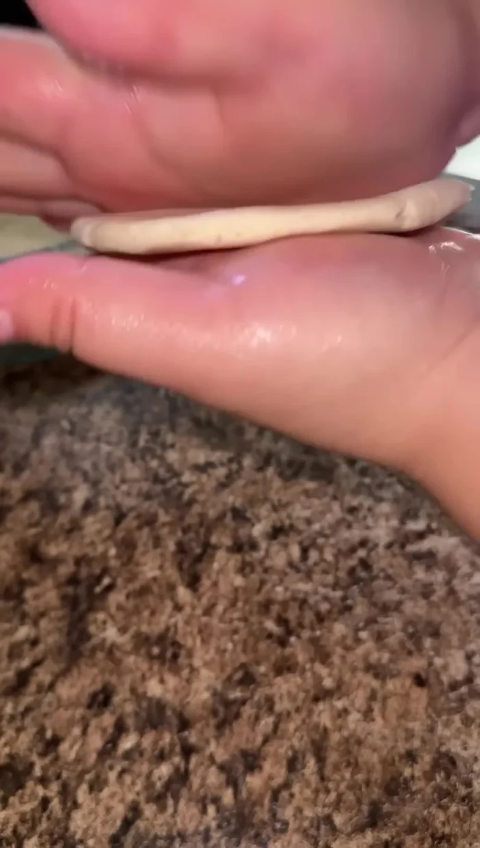 Lightly wet your hands. Take a portion of the dough and pat it into a gordita shape.