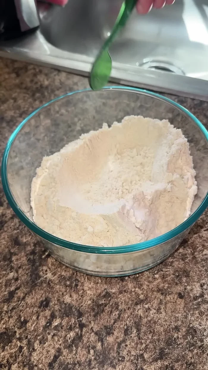 Gradually add 1 1/4 cups of warm water to the Maseca mixture.