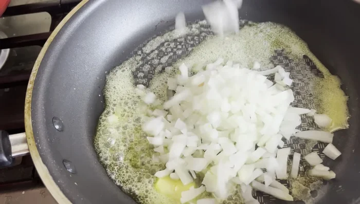 Sauté diced onions and red bell pepper in butter for 2-3 minutes until softened.