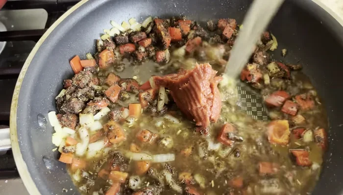 Stir in tomato paste and 1/2 cup of chicken broth; simmer for 1 minute.