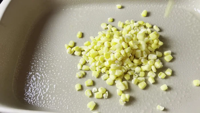 In a 9x13 casserole dish, layer frozen corn, black beans, green chilies, rice, and the tomato-spice mixture.