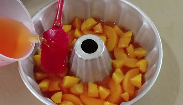Pour remaining peach gelatin over the layered peaches.