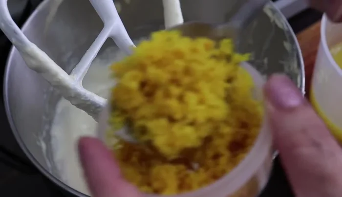 Add 2 tablespoons of orange zest (ensure no white pith is included), 2 tablespoons of vanilla extract, and beat.