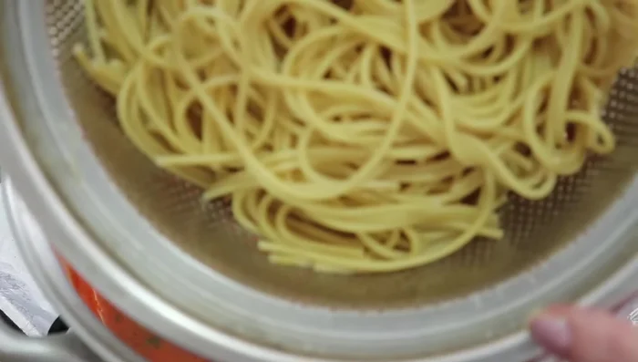 Add the reserved cooked spaghetti to the sauce and let it simmer for another 5 minutes to absorb the flavors.