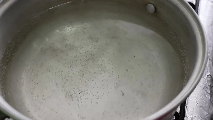 In a separate saucepan, boil water with three bay leaves, salt to taste, and a piece of onion.