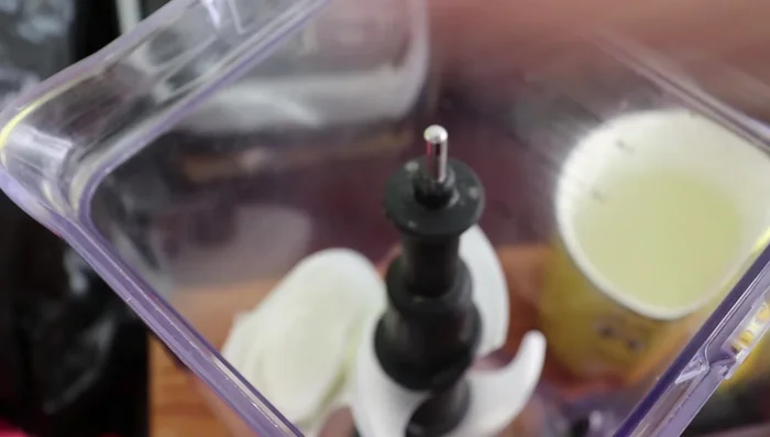 In a blender, combine a piece of onion, chopped garlic, oregano, and the boiled tomatoes.