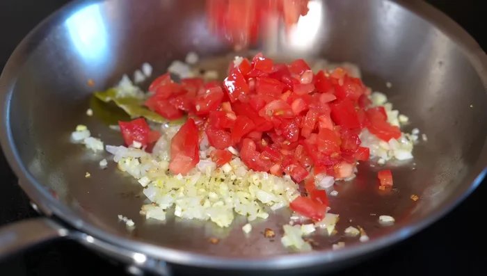 Add the tomatoes and chili. Season with salt and stir. Let the tomatoes cook for 5 minutes.