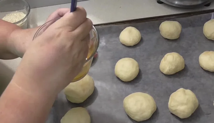 Prepare for baking: Beat an egg and brush it over the balls. Sprinkle with sesame seeds.