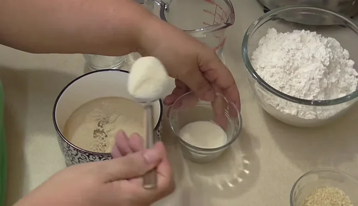 Activate yeast: In warm water (microwaved for 25 seconds), add yeast, 2 tablespoons of sugar, and 2 tablespoons of flour. Stir until dissolved and lump-free. Let rest to activate and rise.
