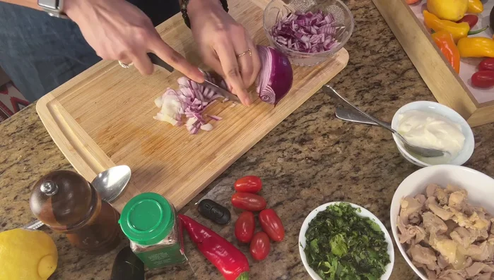 Chop onions, mini sweet peppers, purple cabbage, and cherry tomatoes.