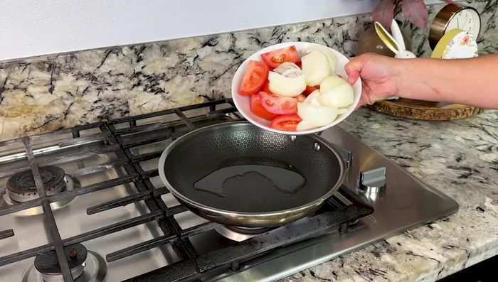 In a pan over medium heat with oil, sauté Roma tomatoes, 1 onion, and 3 garlic cloves for about 5 minutes.