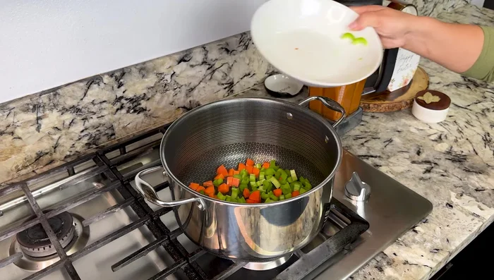 In a pot over medium heat with oil, sauté 3 carrots and 2 celery sticks for 2 minutes.