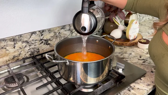 Add the blended tomato mixture, 6 cups boiling water, and 2 bay leaves. Season with salt to taste.