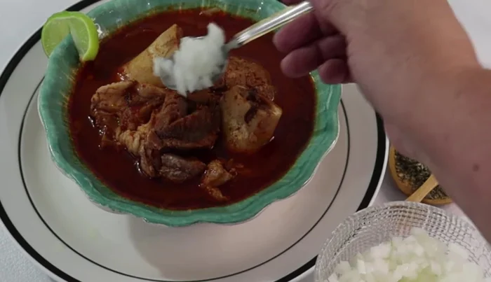 Serve the birria with chopped onion, cilantro, lemon juice, and oregano. Enjoy with warm tortillas or rolls.