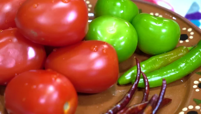 Prepare the salsa: Boil serrano and árbol peppers for 5 minutes. Add tomatoes (without stems), and cook for 3-4 minutes. Add green tomatoes until they turn yellow. Let cool, then blend with onion, garlic, peppers, a little cooking water, and season with salt. Add the cooked tomatoes and green tomatoes and blend again.