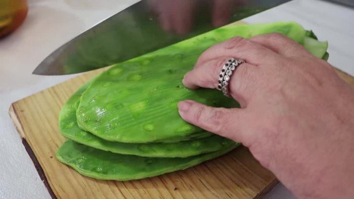 Cut raw nopales into small pieces.