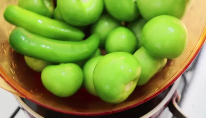 Boil green tomatoes, tomatillos, and green chilies in water until they change color.