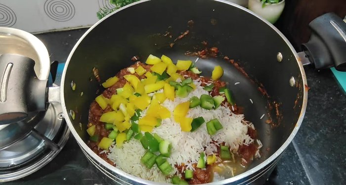 Add chopped vegetables (capsicum, bell peppers, corn, and rajma). Mix gently.