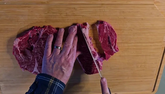 Cut chuck steak into bite-sized cubes and coat in seasoned flour (flour, salt, pepper, garlic powder).