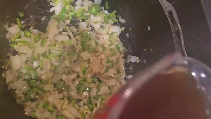 Add beef broth to the onion and jalapeno mixture. Pour chili sauce into the pan, stir in the browned beef.