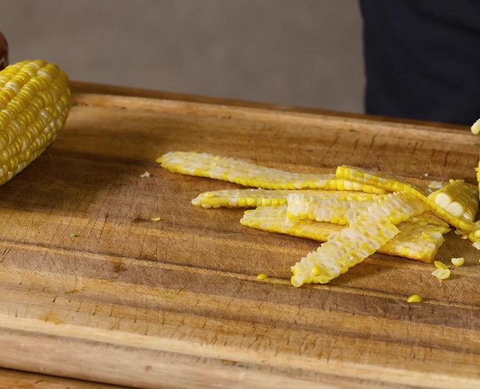Prepare elote en vaso: Cut kernels off the corn cob. Fill a cup with the kernels.