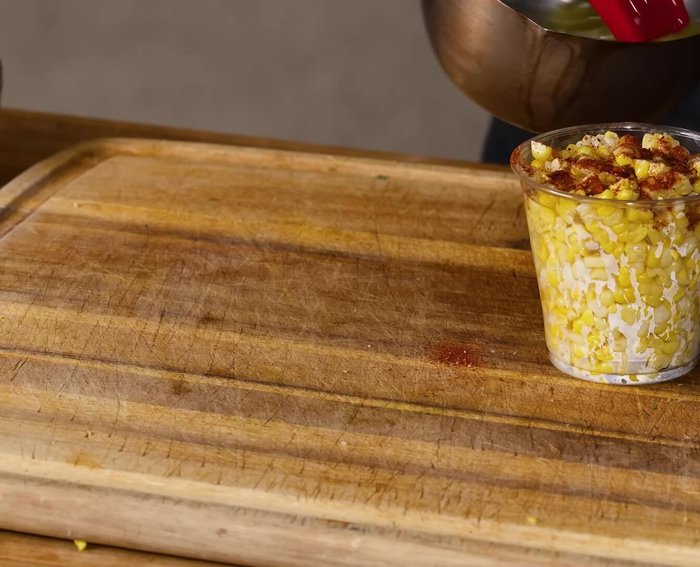 Assemble the Elote en Vaso: Add the chili powder mixture, mayonnaise, cilantro, and cotija cheese. Drizzle with butter.