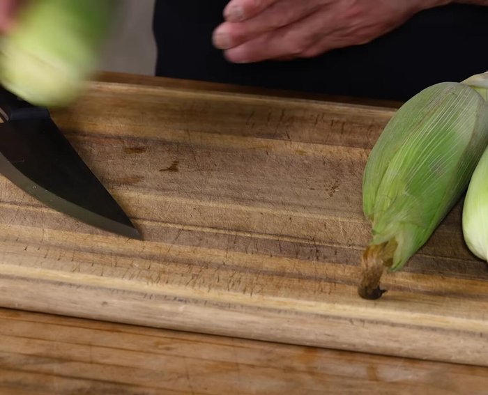 Prepare the corn: Rinse the corn cobs. Remove the outer layer and most of the silk. Soak the corn in water for 15-20 minutes.