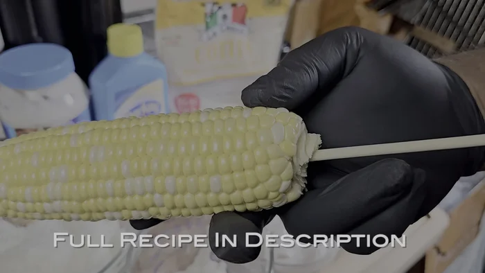 Insert a wooden skewer into the bottom of each corn on the cob.