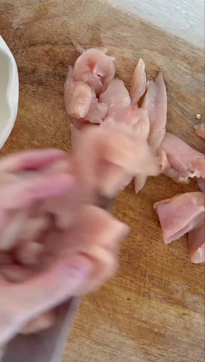 Slice 400g of chicken fillet finely.