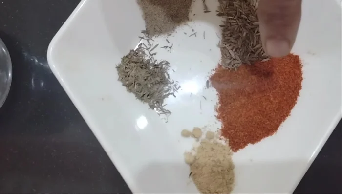 Combine chicken with garlic powder, red chili powder, cumin, salt, black pepper, thyme, vinegar, and chili sauce. Mix well and refrigerate for 30 minutes. (55.199)