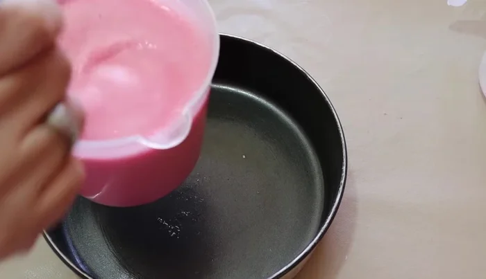 Remove the molds from the freezer. Pour the strawberry gelatin mixture into one mold, add fruit pieces, and refrigerate until set.