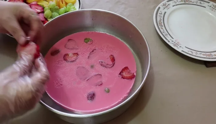 Add a layer of fruit to the semi-set clear gelatin.