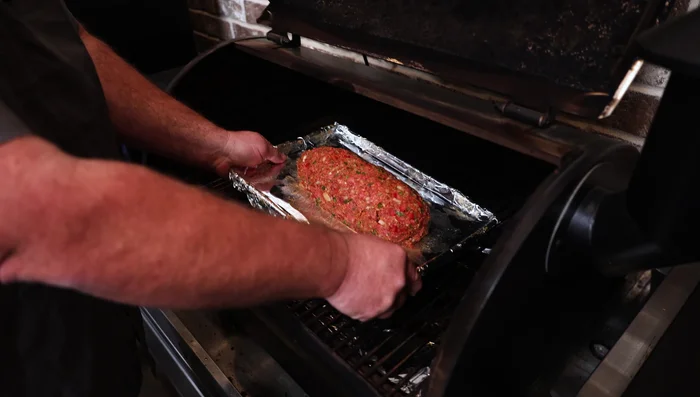 Smoke the meatloaf at 350°F for about 30 minutes, then rotate it for even cooking.