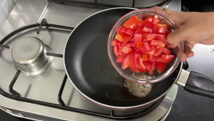 For the gravy: Heat 2 tablespoons of oil in a pan. Add cumin seeds, chopped tomatoes, Kashmiri chili, almonds, and 1/2 bowl of water. Cook for 5-6 minutes on medium flame.