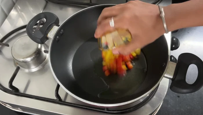 Heat 1 tablespoon of oil in a pan. Add bell peppers, capsicum, zucchini, corn, and kidney beans. Mix well.