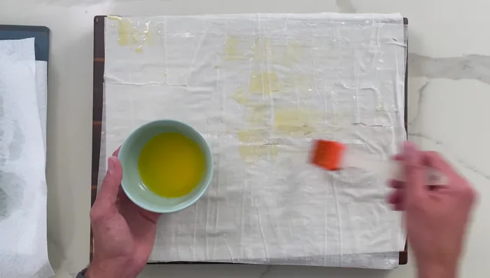 Brush phyllo dough sheets with melted butter, cut into 9 rectangles.
