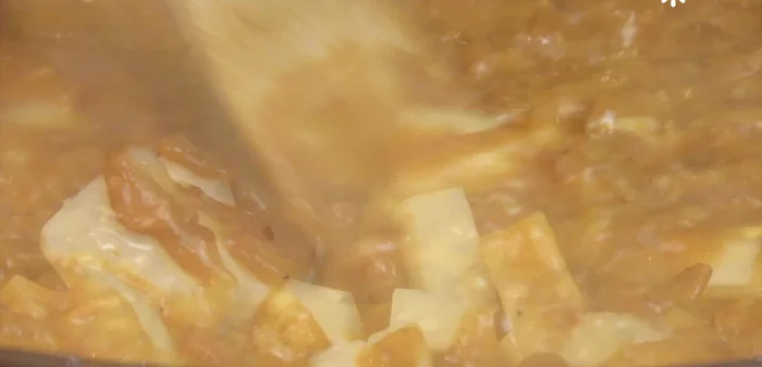 Add about half a cup of the bean cooking broth. Reduce heat and stir constantly.