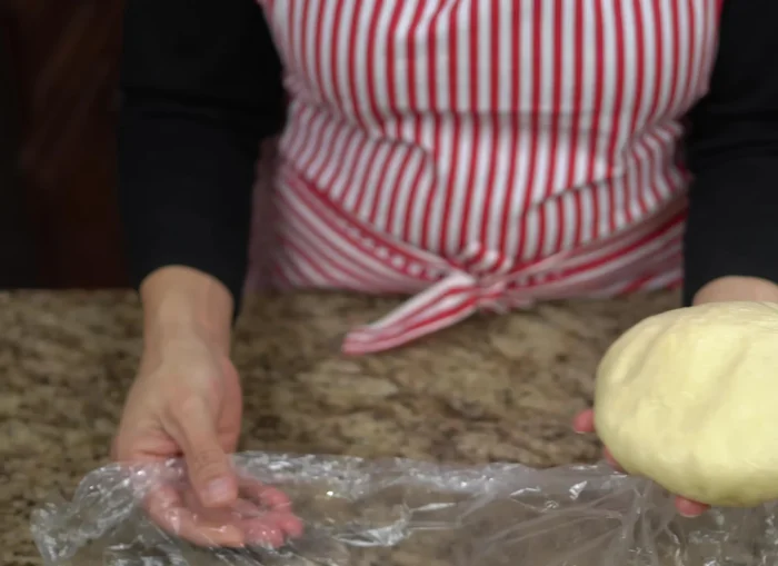 After resting, divide the dough into 40-gram portions. Lightly grease each portion with shortening and roll into balls.