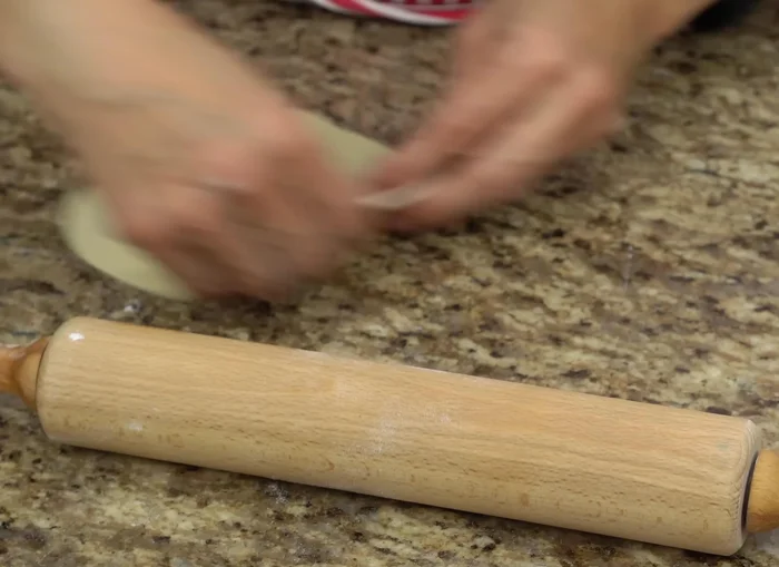 Lightly dust each dough ball with flour and use a rolling pin to stretch it into a thin, circular shape. The dough should be translucent.