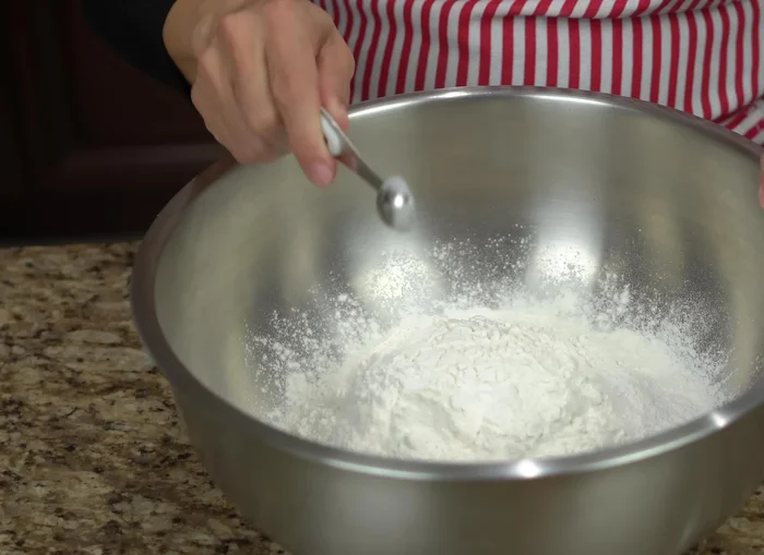 Prepare the dough: In a container, mix together flour, baking powder, and salt. Add vegetable shortening (or pork fat) and mix until incorporated.