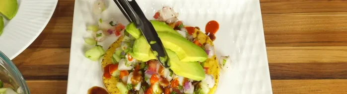 Combine ingredients: Once cured, gently remove some of the excess lime juice from the fish. In a larger bowl, combine the fish with the prepared vegetables: cucumber, tomato, red onion, serrano peppers, and cilantro (5:04).