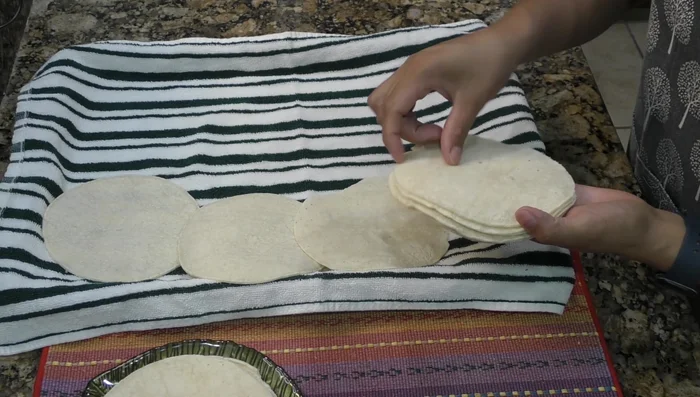Prepare the tortillas: Place tortillas on a tray lined with paper napkins. Let them sit for at least two hours, or preferably overnight, to prevent them from absorbing too much oil when frying.