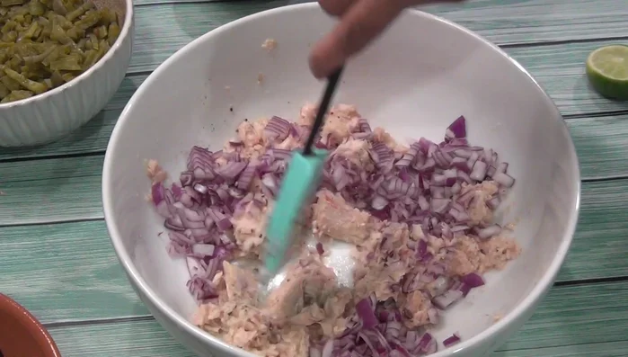 In a bowl, combine the chopped onion, chili, cilantro, tuna, tomatoes, and nopales.