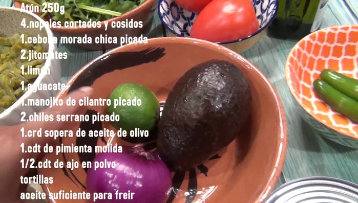 Chop the red onion, lemon, avocado, serrano peppers, tomatoes, and cilantro.