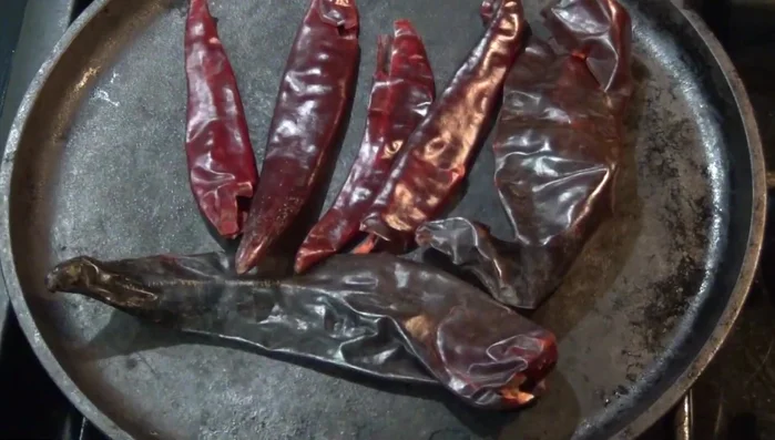 Toast the guajillo and other chilies in a dry pan until fragrant. Be careful not to burn them.