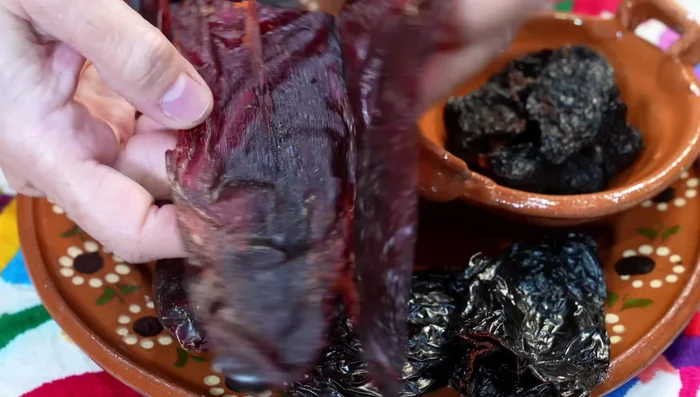 Prepare the sauce: In hot water, add morita, guajillo, and ancho chiles. Bring to a boil, then add green tomatoes. Remove when they change color.