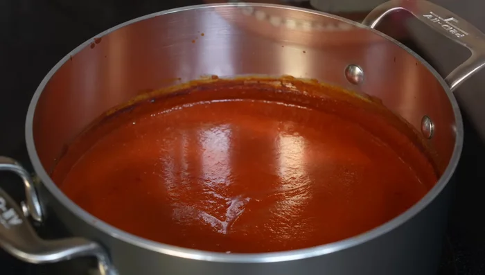 Add shredded chicken to the sauce. Simmer for a few minutes to heat through and combine flavors.