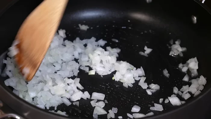 In a pan with hot oil, sauté the onion for 5 minutes. Add garlic and serrano peppers (if using) and cook for 1 minute.