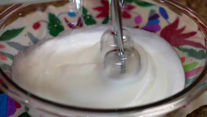 Gently fold in the egg yolks into the beaten egg whites.